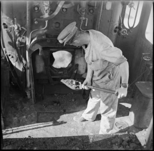 Member of the New Zealand Railway Operating Company firing a railway engine, Western Desert, World War II