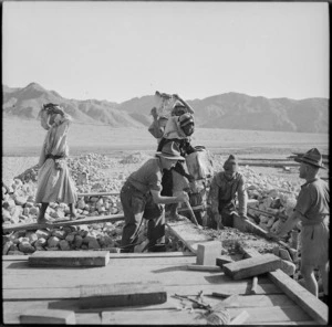 Local workers pouring concrete as the 21 NZ Mechanical Equipment Company constructs road in Trans Jordania, World War II - Photograph taken by M D Elias