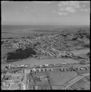 The coastal town of Patea and the Patea Freezing Works in the foreground with rail yards and the West Coast Refrigeration Co Ltd factory alongside the Patea River, South Taranaki Region