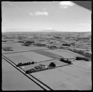 View of farmland with a main road and farmhouse in foreground to Mount Taranaki beyond, Waverley District, South Taranaki Region