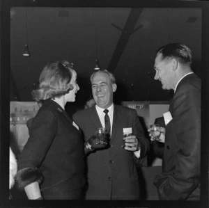 Two unidentified men and an unidentified woman at a function for British Overseas Airways Corporation
