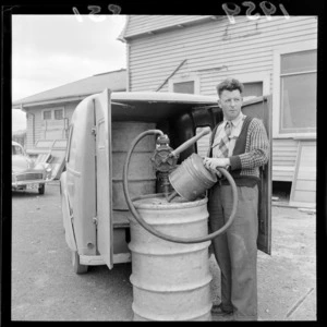 Unidentified man with petrol pump and drum at Rongotai Aero Club, Wellington