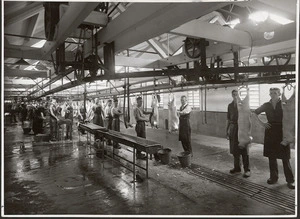 Butchers working on carcasses in a meat works - Photograph taken by Green and Hahn