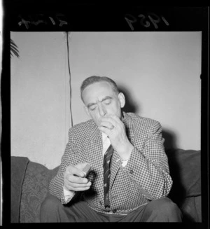 A W Wilson, manager of the 1959 British Lions rugby union team's tour of New Zealand, who is lighting a cigarette