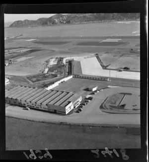 Aerial view of Wellington Airport, showing terminal buildings, carpark, and construction work, with Lyall Bay in distance