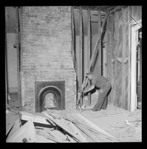 Demolition of Myer's home, Hobson Street, Wellington, showing an unidentified man removing building materials from interior