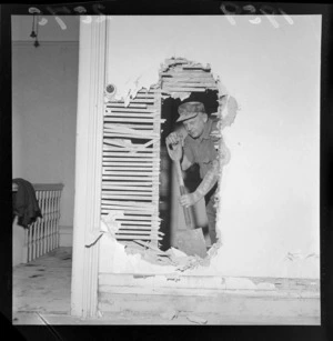 Demolition of Myer's home, Hobson Street, Wellington, showing an unidentified man removing an interior wall