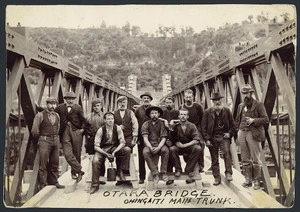 Group, including workmen, on the Otara swing bridge, Ohingaiti