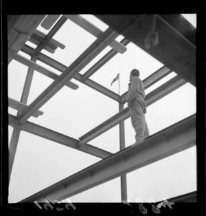 An unidentified man standing on a steel girder, at construction site for Shell building, The Terrace, Wellington