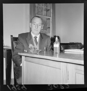 Mr Fred Hackett, Minister of Mines, sitting at a table