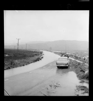 Road closure caused by flooding, officers by side of road, probably on Grays Road, Pauatahanui, Porirua