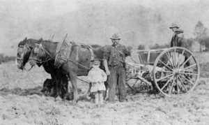 Man and boy alongside a horse drawn seed drill