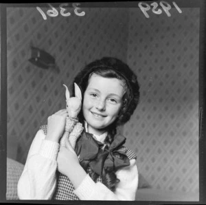 Portrait of Marilyn Buchanan Murray, 9 year old actress, holding a toy lamb, probably in Wellington