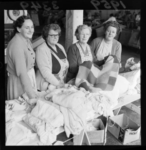 Unidentified mature female collectors for CORSO, sorting quilts and blankets, probably in Wellington