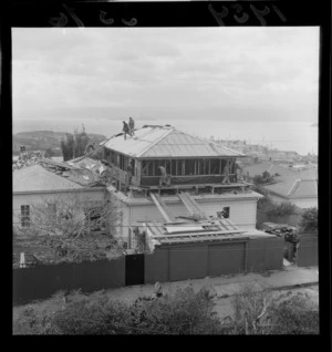 Exterior view of men attempting to build the second storey of a house in one day, Wesley Road, Wellington