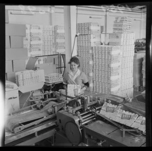 Unidentified woman processing empty egg cartons, at a Lower Hutt factory, Wellington