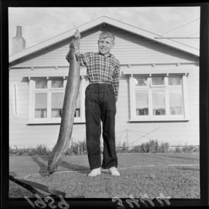 Dean Farrow outside his house in Petone, with an eel he caught