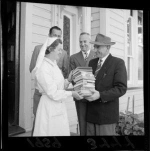 L Jenkins, Matron at Kowhai Home, [Wellington?] receiving books from unidentified men