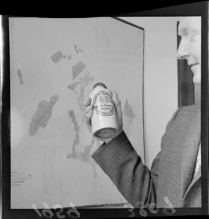 Obscured person holding Thomson Lewis & Company home brewed ginger beer bottle found outside Town Hall, Wellington