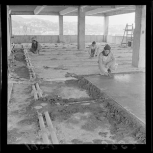 Electrical and communications circuits at Shell House, view of unidentified workmen pouring a concrete floor during construction of building, The Terrace, Wellington City