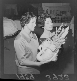 Unidentified women modelling hair styles, one holding flower arrangement in a ceramic swan