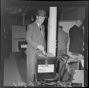 Mr E R Toop, dropping his voting papers into box, at the Town Hall polling booth, Wellington, during [mayoral ?] elections