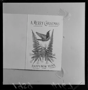 Close-up of a Christmas card with a tui and plants using leaves