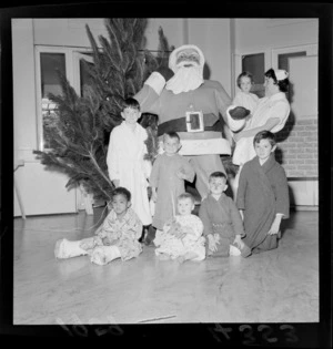 A nurse with child patients, all unidentified, in [Wellington?] hospital, at Christmas