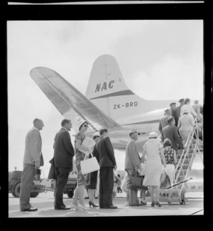 Queue of unidentified travellers embarking National Airways Corporation (NAC) aeroplane ZK-BRD, at Wellington Airport