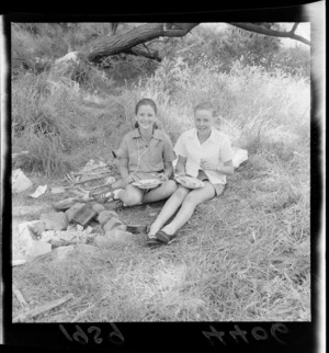 Two unidentified members of the Girl Guides, eating a meal at a campsite, Makara, Wellington