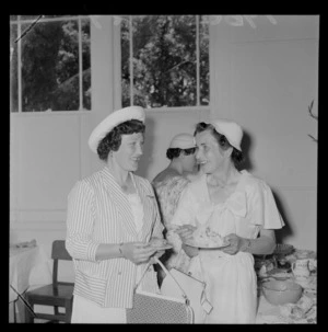 Personalities at the Tauherenikau Racecourse with two unidentified women indoors dressed for the occasion, Wairarapa District