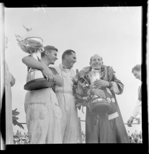 Stirling Moss and Bruce McLaren with winners cups with Jack Brabham, Ardmore Aerodrome Racetrack, South Auckland