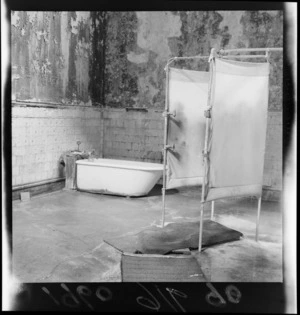 Interior view of dilapidated walls within Rotorua Bath House with bath and shower, Bay of Plenty Region