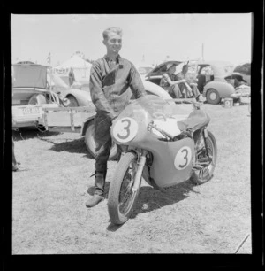 Unidentified race member with his racing bike, at the New Zealand Grand Prix, Ardmore Airport, Manukau, Auckland