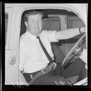 Unidentified man inside car, wearing safety belt