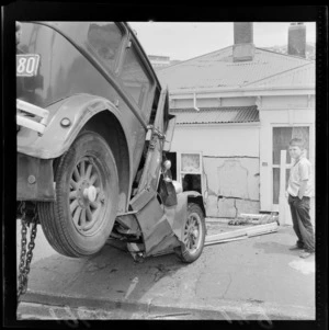 Unidentified young boy watches on as a damaged vehicle is being pulled away from house, leaving damages to front of house, Newtown, Wellington