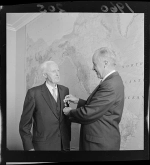 Francis H Russell pins the American Distinguished Service medal on Major General Sir W Sinclair, in front of map of America