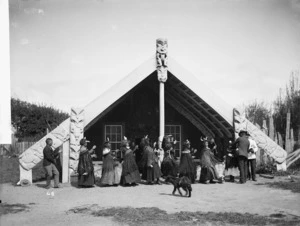 Group, including women with poi, alongside Te Paku-o-te-rangi meeting house - Photograph taken by William Henry Thomas Partington