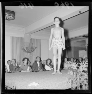 Fashion parade at St George Hotel, Wellington, showing unidentified young boy model, with audience watching