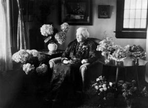 Ann Finnimore surrounded by vases of flowers