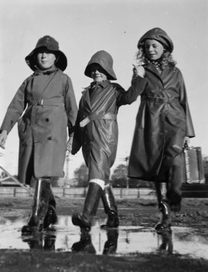 Three children dressed in wet weather clothes