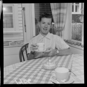 Kevin Johnson, sitting at a table, after cycling non-stop from Auckland, probably Wellington Region