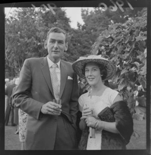 Garden party at Homewood with an unidentified couple in front of trees, Karori, Wellington
