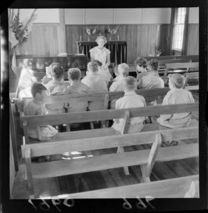 Levin Training Farm for handicapped children with unidentified boys and a teacher within a church, Levin, North Wellington Region