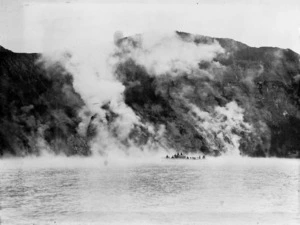 Lake Rotomohana with steam rising and a group on a boat
