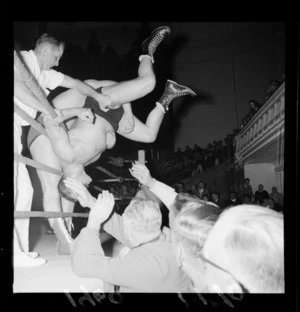American wrestler, Lou Newman, being bundled out of the ring by Ricky Wallis during a wrestling match, Wellington Town Hall