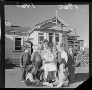 Young children gathered around unidentified woman having a story read to them, Anglican Children's Home, Messines Road, Karori, Wellington