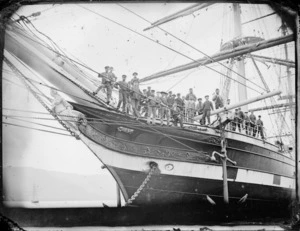 The prow of the sailing ship Lady Ruthven at Port Chalmers, showing the figurehead, and crew members posing on deck for the camera below.