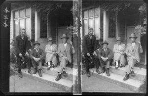 Group sitting on steps at entrance to a house, including William Williams, second from left, and Lydia Williams, location unidentified