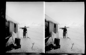 Unidentified skier, with poles and skies, outside a hut, Mount Cook National Park, Canterbury Region